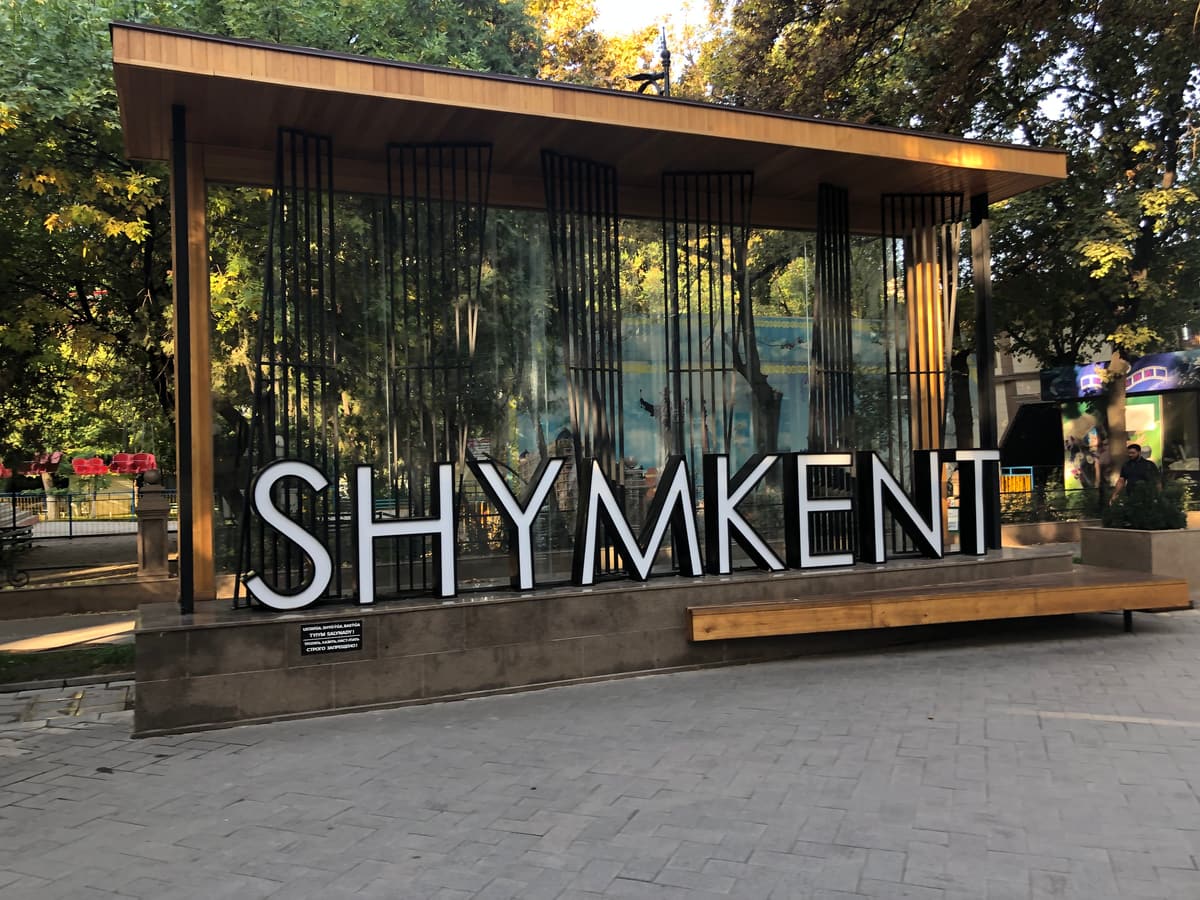 Şehir merkezinde bir yaya yolunda büyük SHYMKENT yazısı